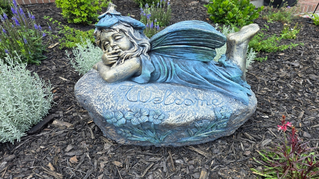 Fairy laying down on a rock that says welcome