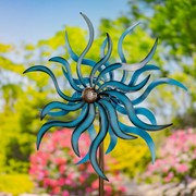 Decorative metal birdhouse on stake displayed in a garden setting