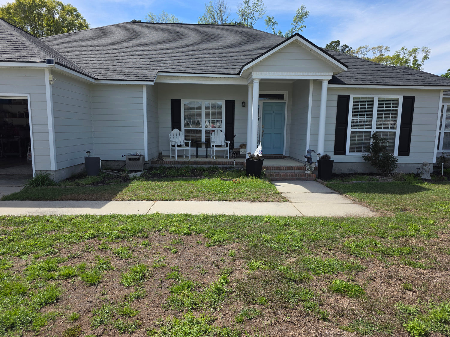 House with a front porch and lawn on a sunny day