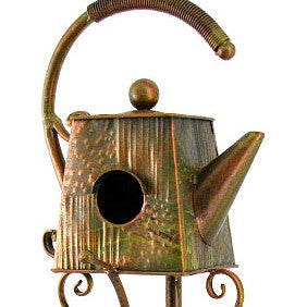 Decorative teapot with a birdhouse design on a white background