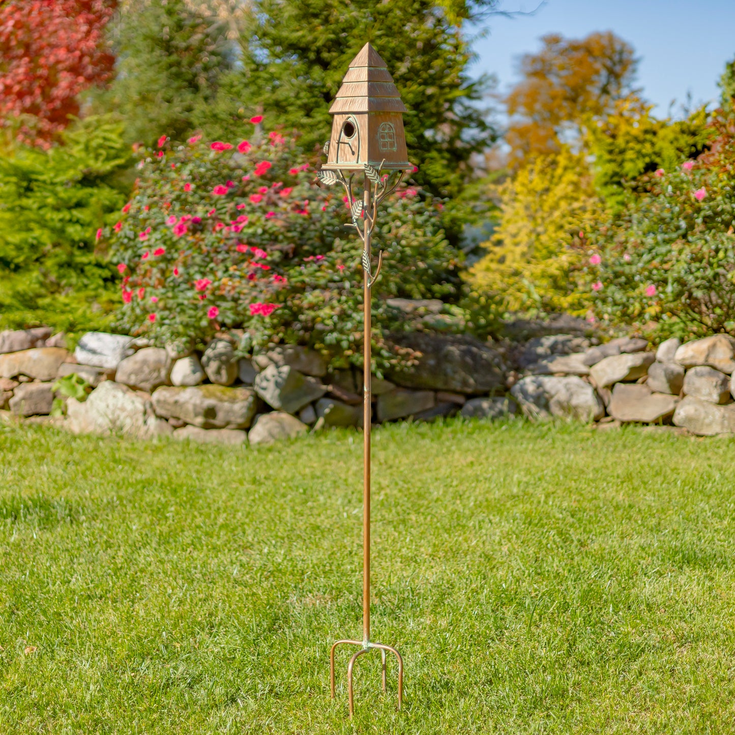 Decorative garden stake with birdhouse in a garden setting