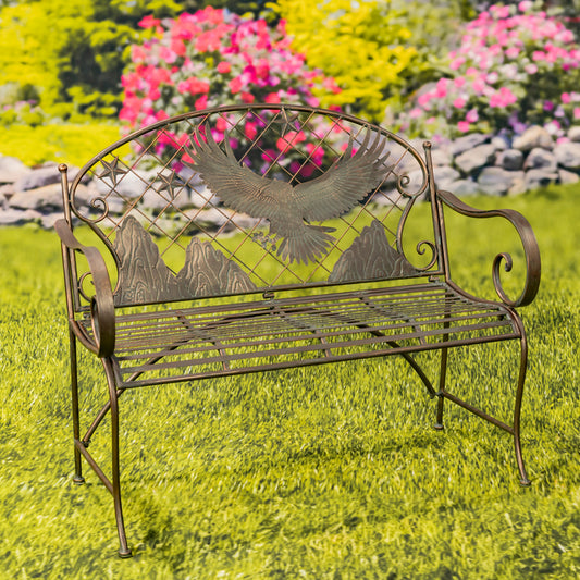 Decorative metal bench with eagle design in a garden setting