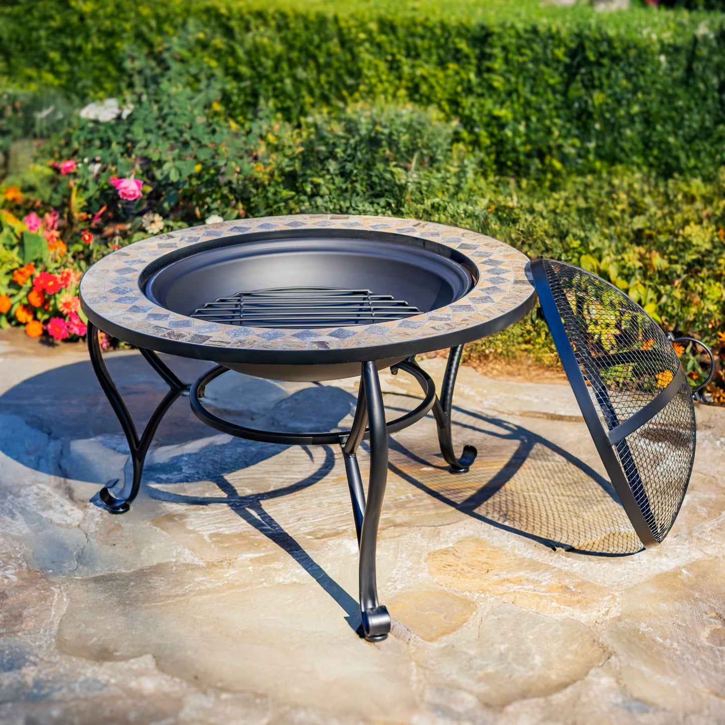 Round outdoor fire pit table with decorative edge on a stone patio