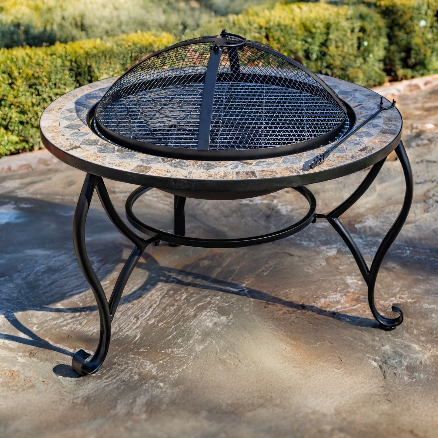 Round outdoor fire pit with a metal cover on a stone patio