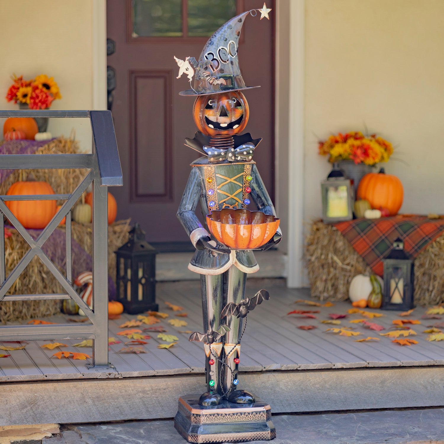 Decorative Halloween totem with pumpkins and a witch hat on a porch.