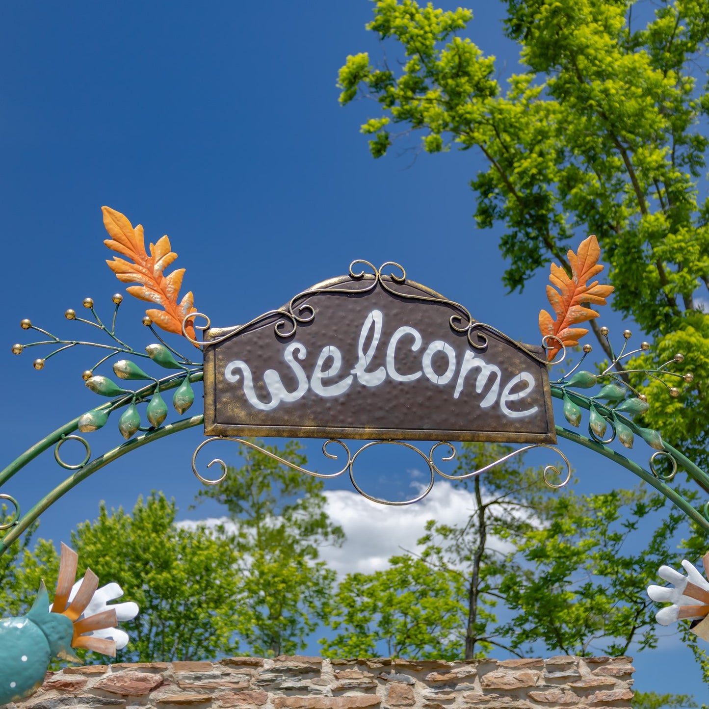 top of arch with welcome sign with orange and green leaves
