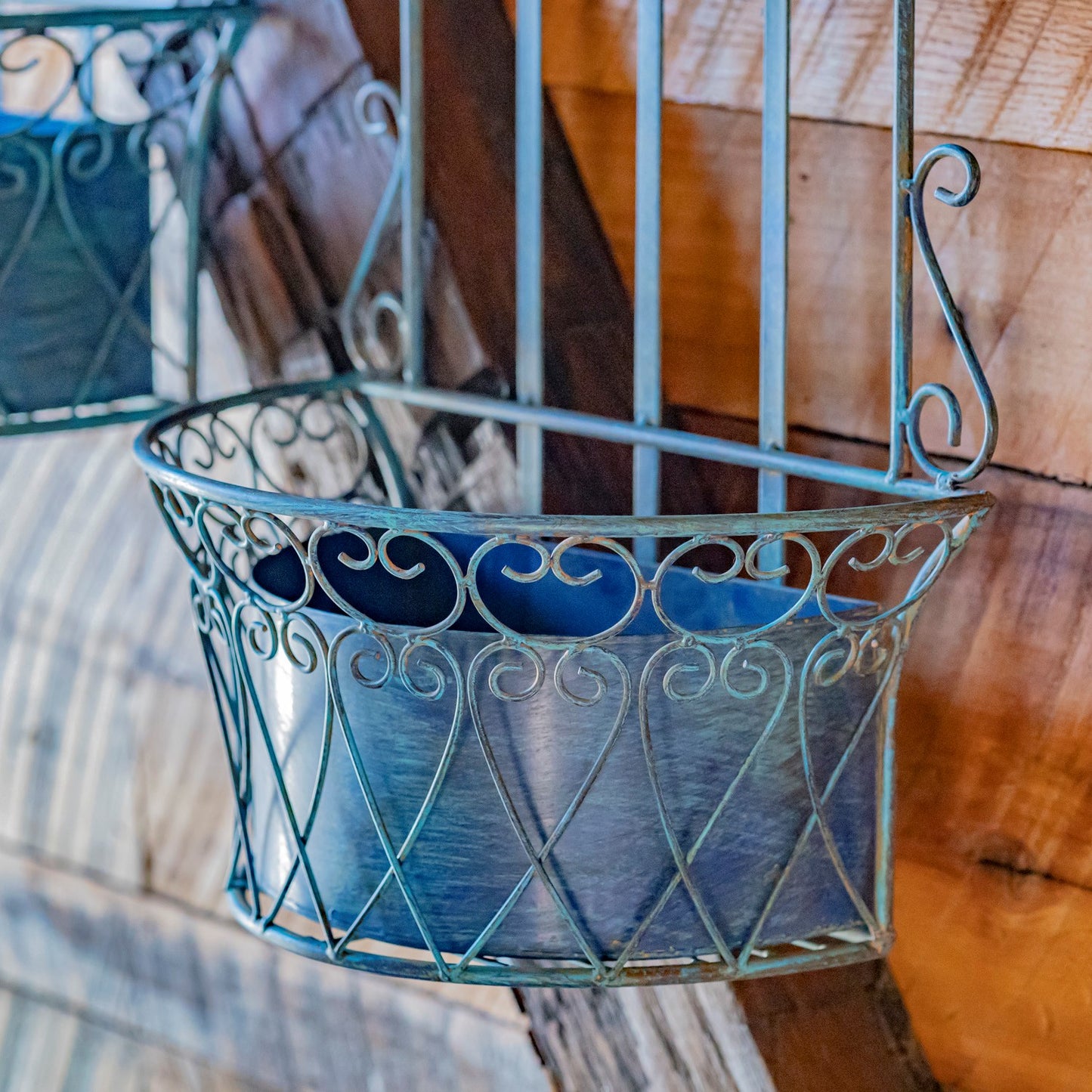 Decorative metal wall basket with blue interior on a wooden surface