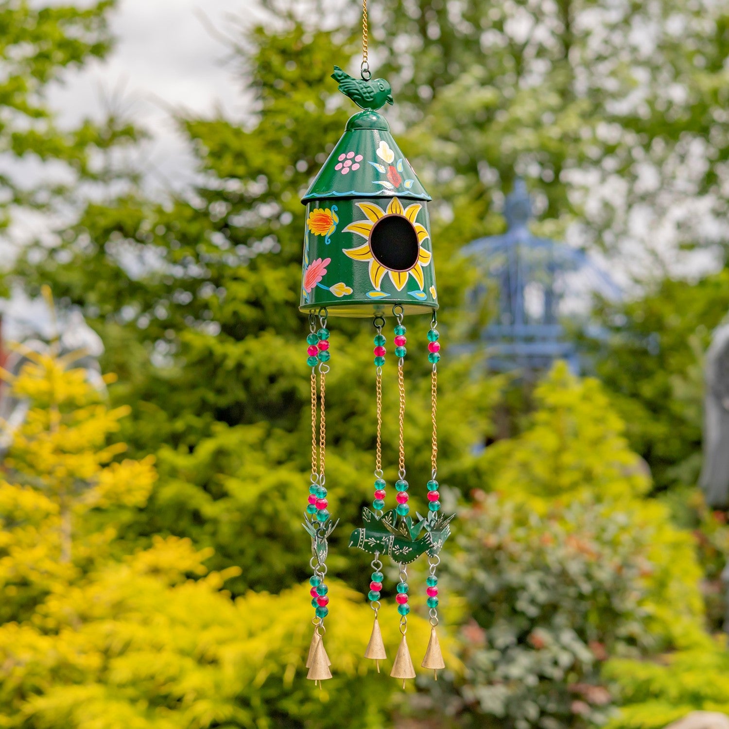 Decorative wind chime with birdhouse design hanging outdoors