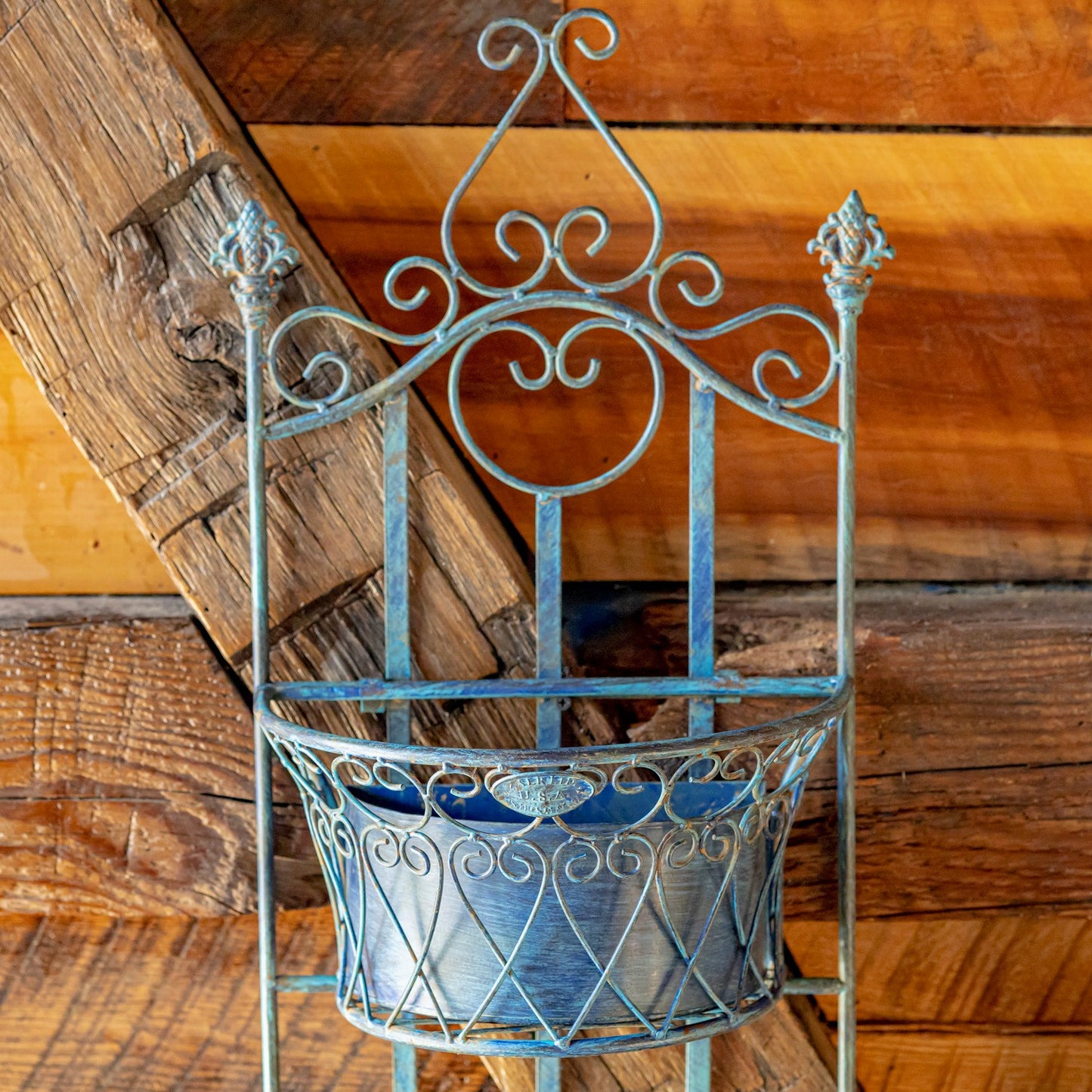 Decorative metal wall planter against a wooden background