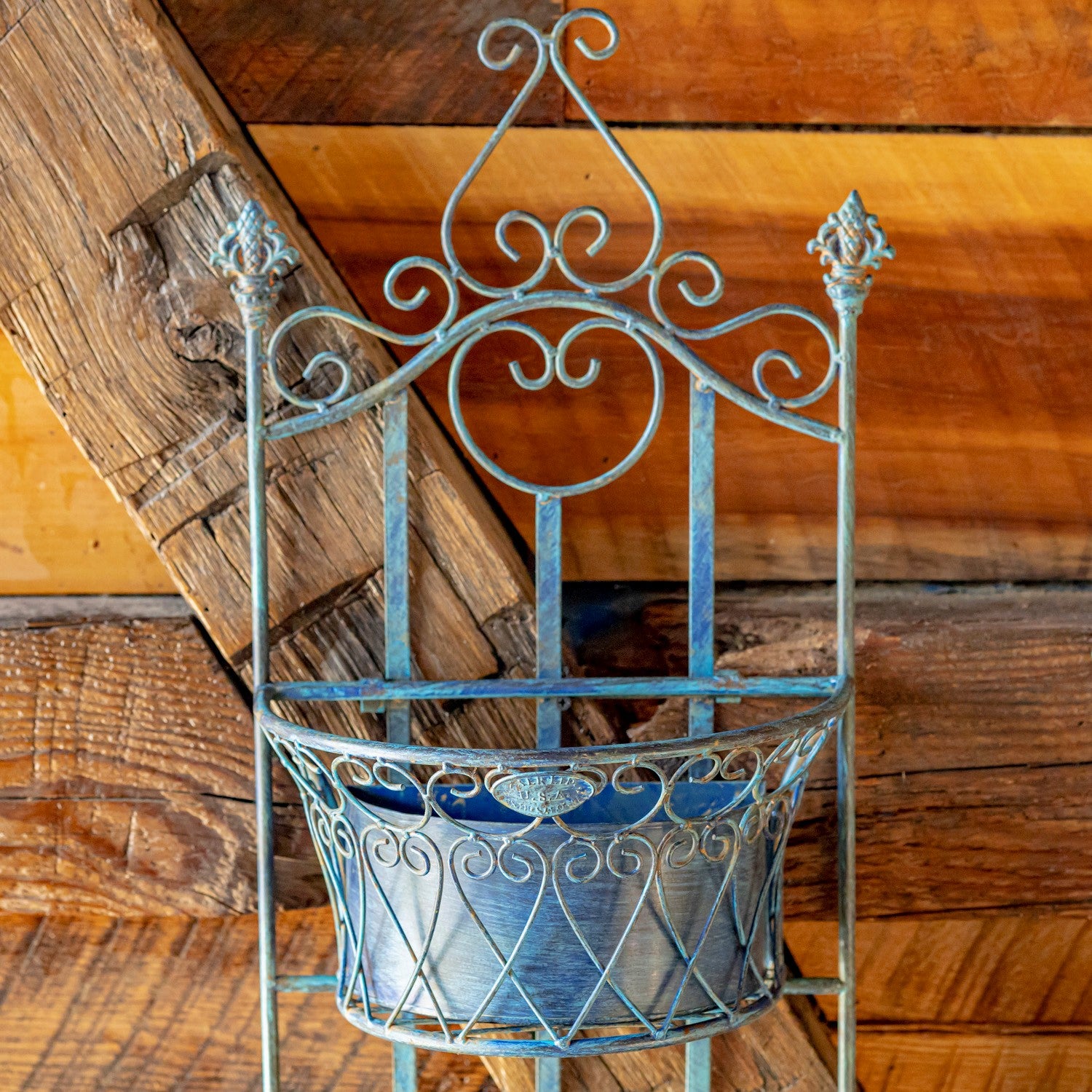 Decorative metal wall planter against a wooden background