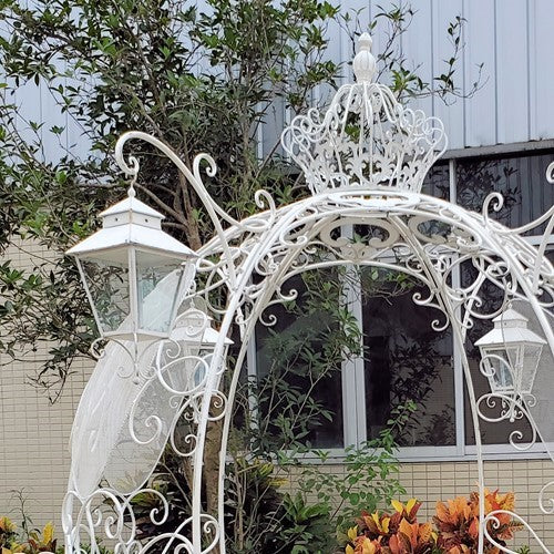 White egg shaped carriage bench and plant stand with lanterns