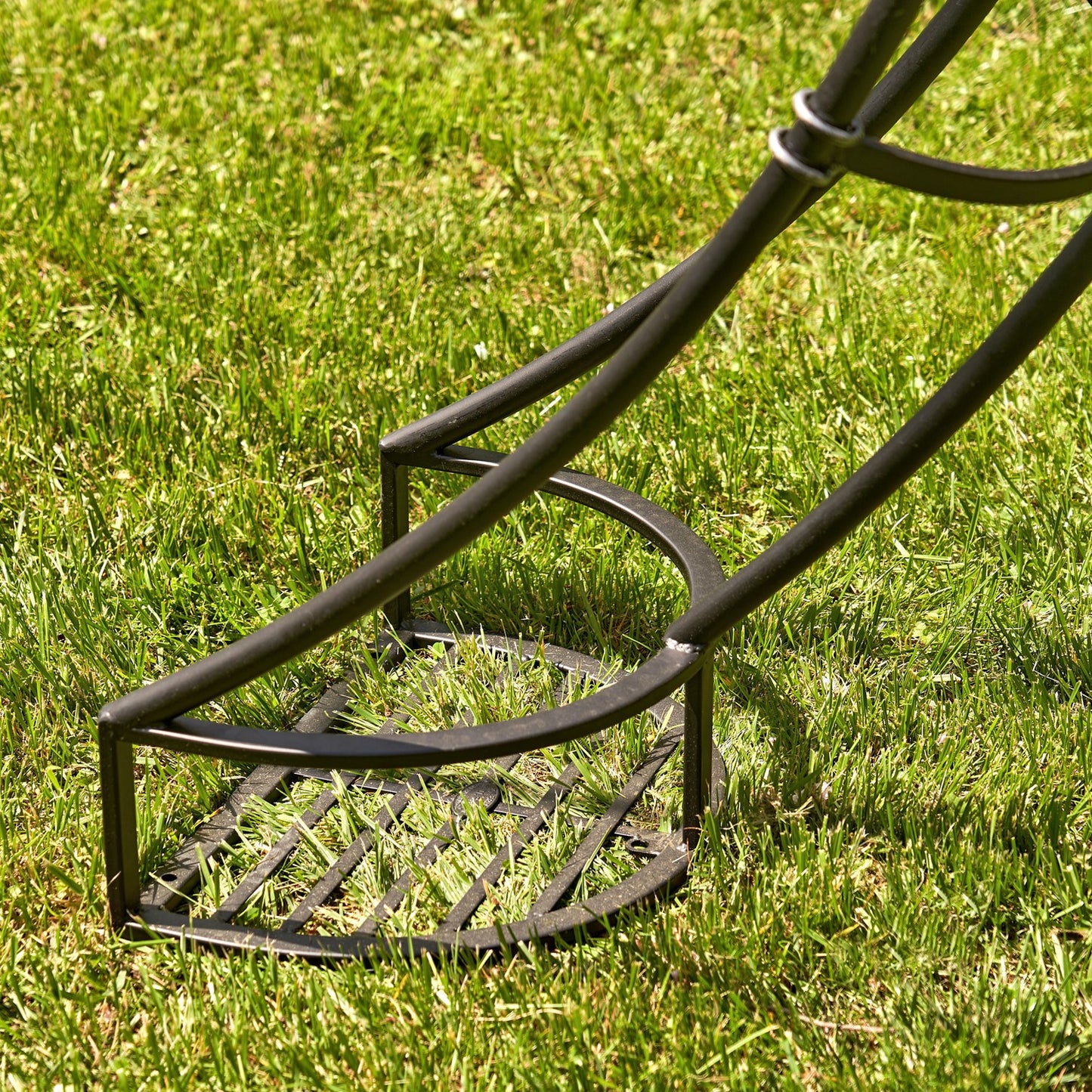 Metal  black plant stand at the foot of moon gate