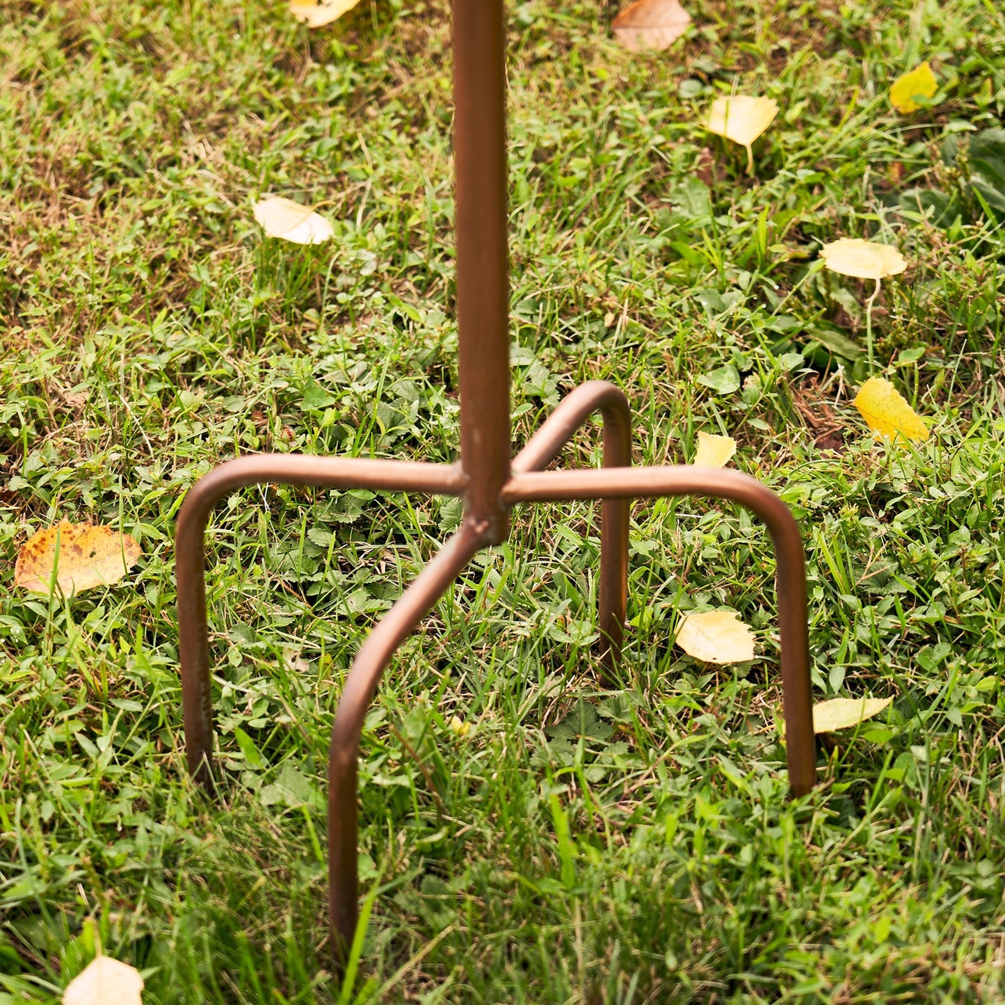 Metal stand with a decorative item on grass