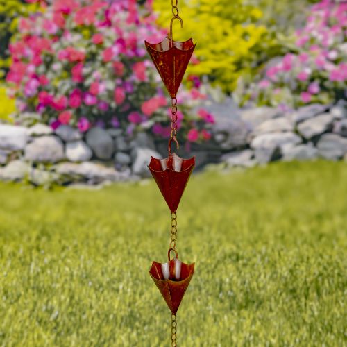Decorative red rain chain with a garden background