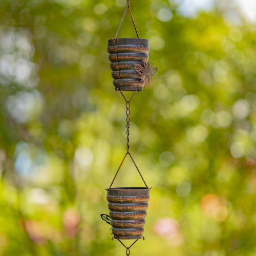 Decorative hanging planters with a rustic design against a blurred green background
